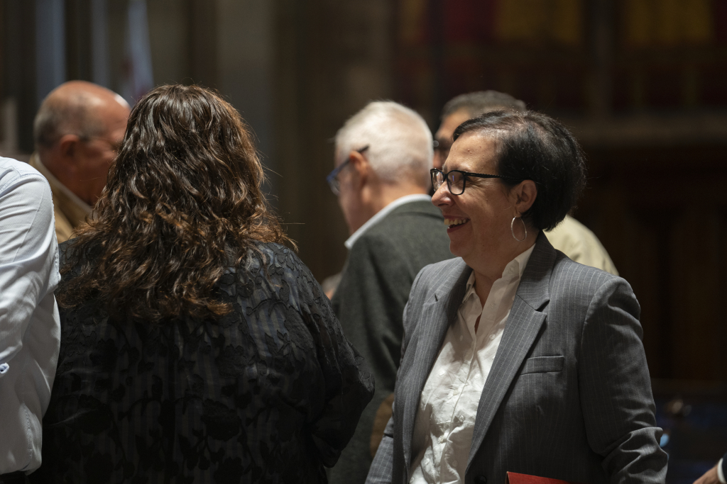 Imatge de la regidora Raquel Gil entre diverses persones d'esquena