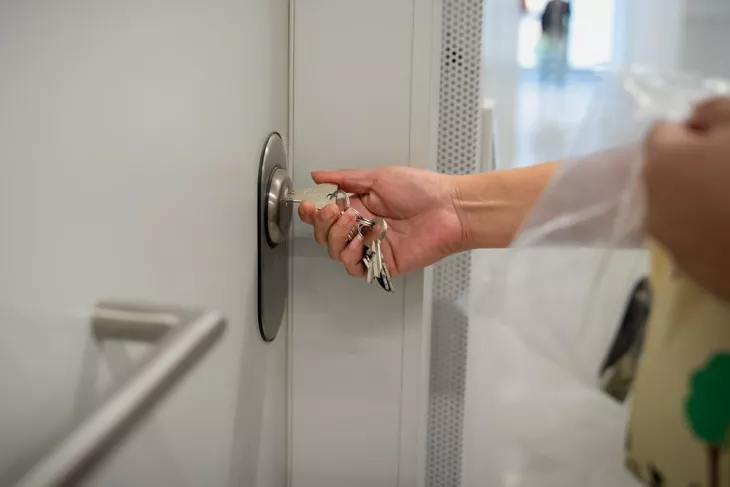 Hand turning the keys in the front door of a flat in Barcelona