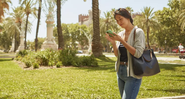 Chica consultando el móvil en el Passeig Lluís Companys de Barcelona