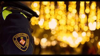 A Guàrdia Urbana police officer patrolling a street in Barcelona, which is decorated for Christmas.