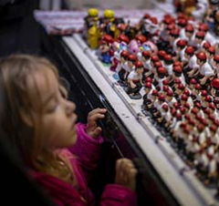 A little girl looks in awe at the caganers on display at a stall at the Sant Llúcia Fair