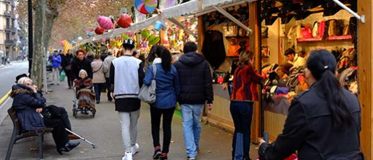 Personas miran juguetes en un puesto de la feria de Reyes de la Gran Vía