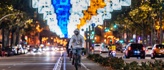 Cyclist riding along an illuminated Barcelona street